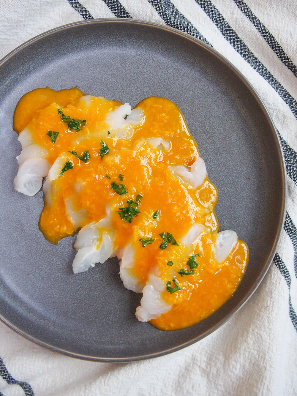 Tiradito is a Peruvian take on sashimi, with a spicy citrus sauce. It's easy to prepare, light and with a wonderful chili kick! Tiradito - Peruvian sashimi with chili sauce plate from overhead