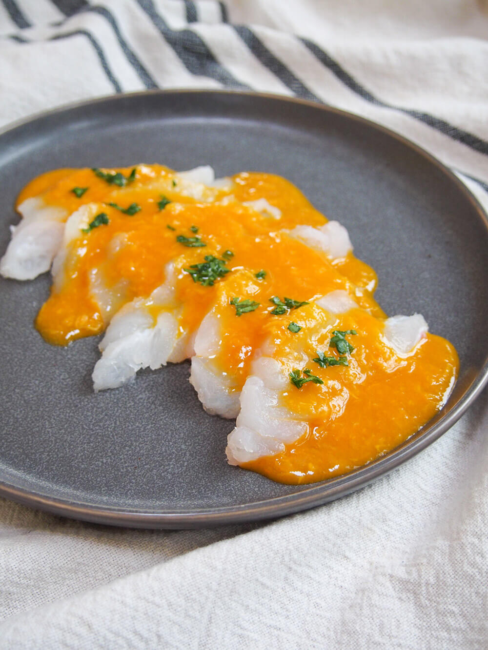 Tiradito is a Peruvian take on sashimi, with a spicy citrus sauce. It's easy to prepare, light and with a wonderful chili kick! Tiradito - Peruvian sashimi with chili sauce - on plate