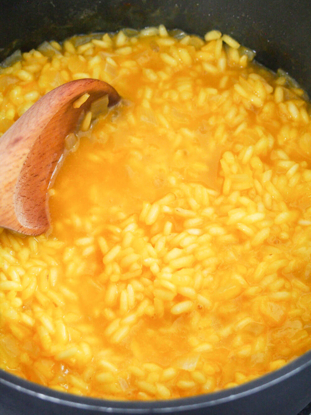 adding final stock and saffron to rice