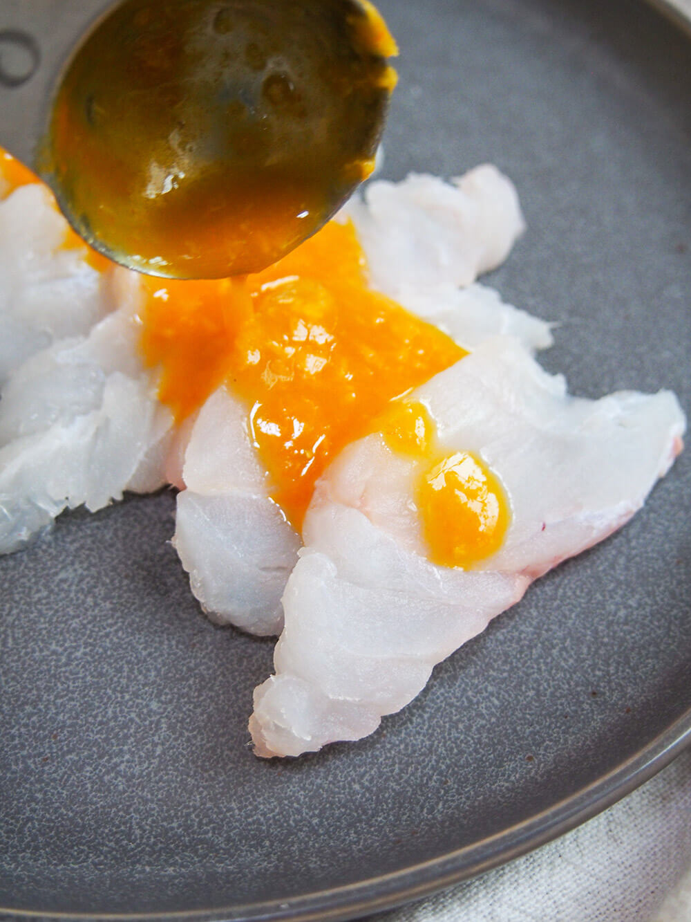 putting sauce over fish for tiradito putting sauce over tiradito - Peruvian sashimi with chili sauce