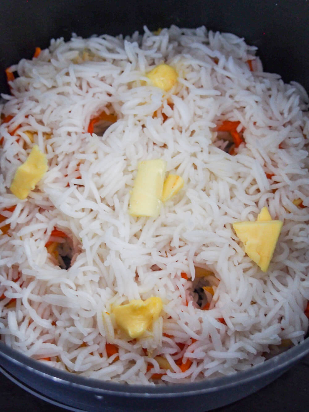 butter on rice and holes for steam for Persian sweet rice (shirin polow) ready to steam