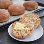 spelt rolls with one cut open with butter in front