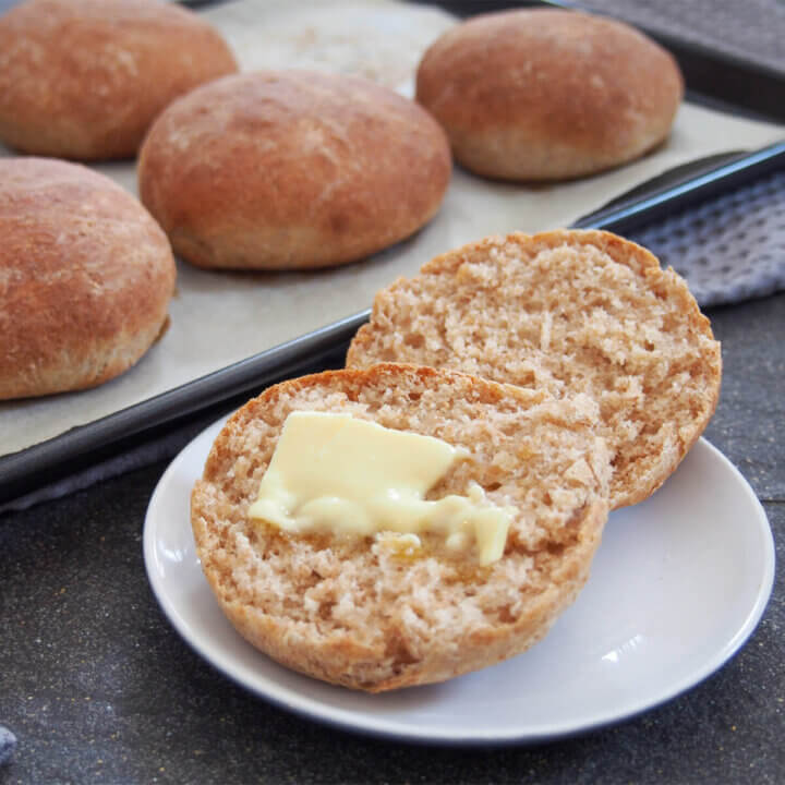 spelt rolls with one cut open with butter in front