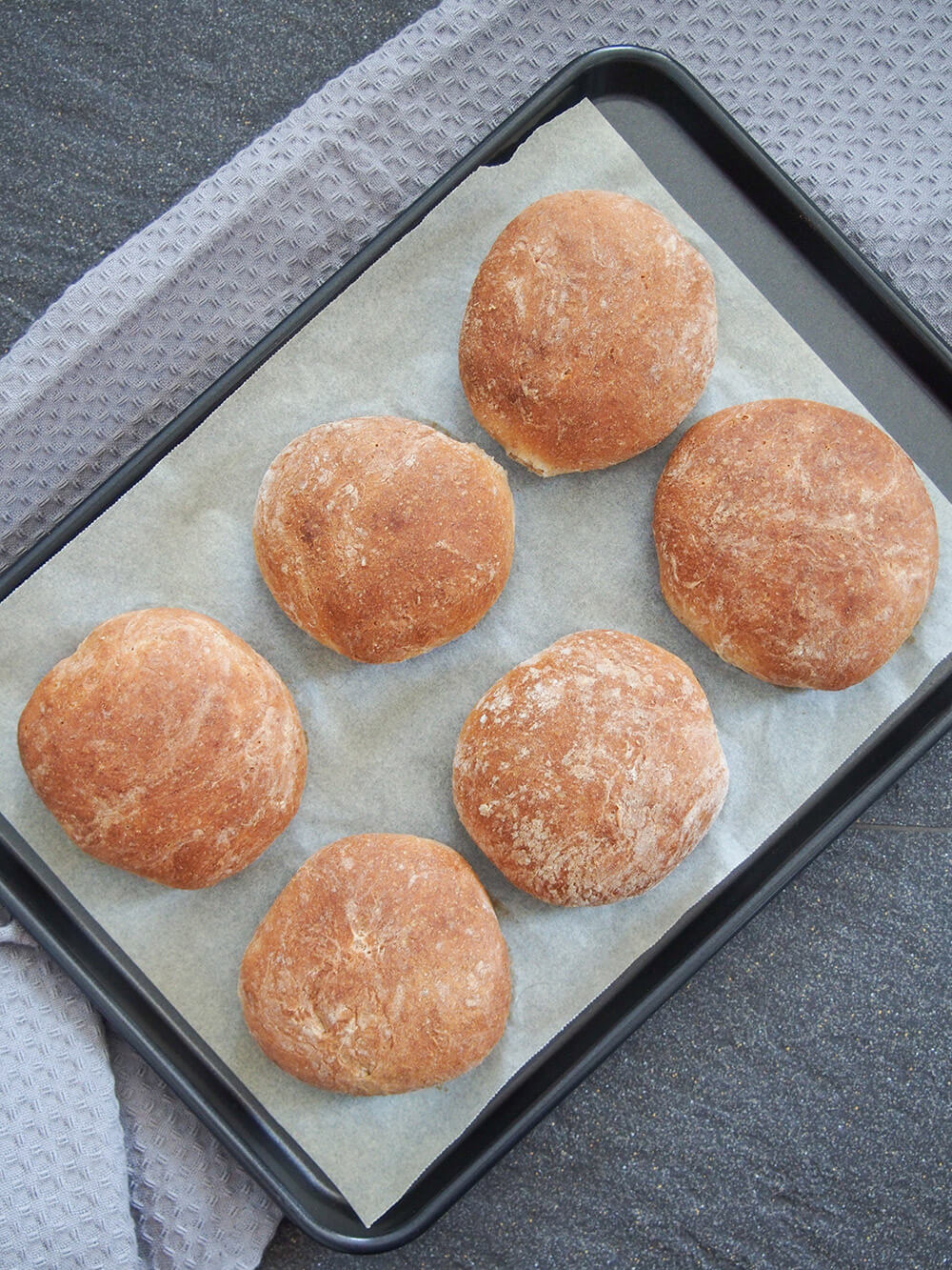 These spelt rolls have a wonderful lightly nutty flavor, tender crumb and are perfect for lunch or as a side to a meal. Soft, flavorful and versatile. spelt rolls on baking sheet from overhead