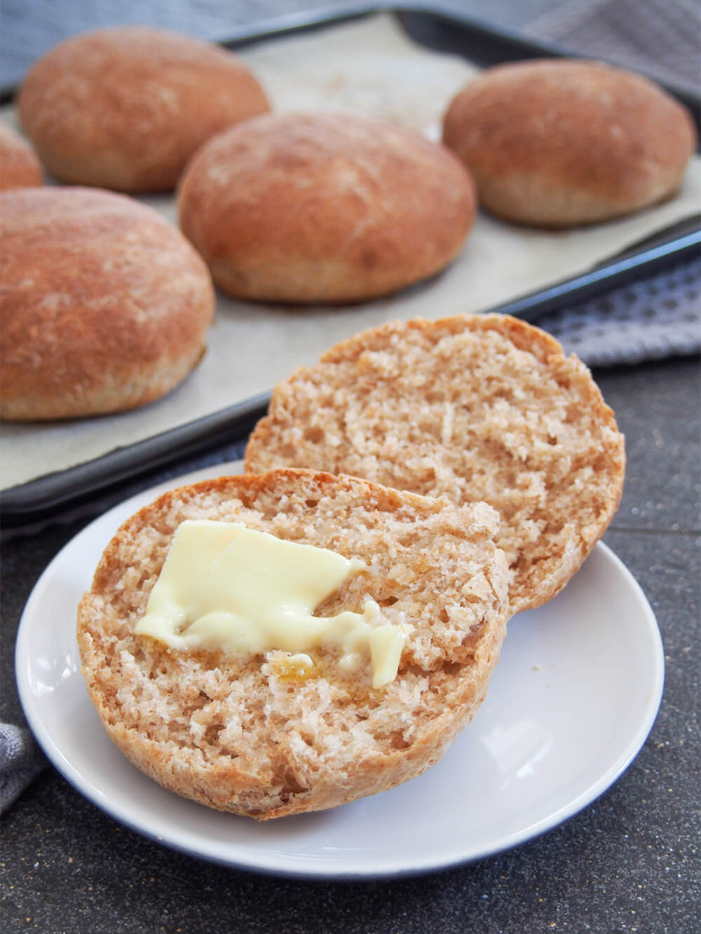 These spelt rolls have a wonderful lightly nutty flavor, tender crumb and are perfect for lunch or as a side to a meal. Soft, flavorful and versatile. spelt roll with butter on top, remaining rolls behind