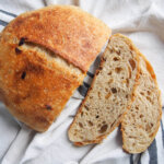 sage and caramelized onion sourdough bread from overhead with two slices to side of loaf