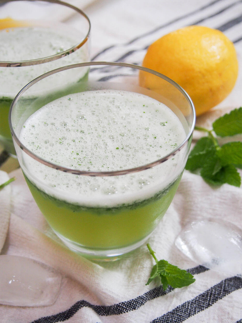 glass of limonona, mint lemonade, with lemon behind glass