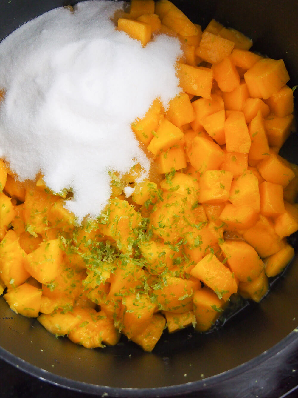 mango, lime and sugar in pan ready to cook