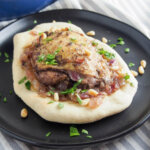 Musakhan (Palestinian sumac chicken) served on bread on a plate