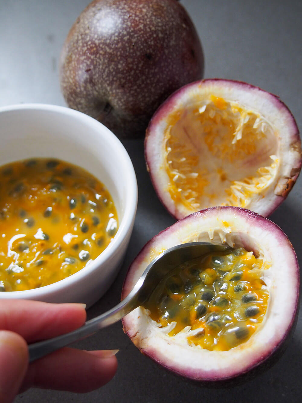 scooping seeds from passion fruit