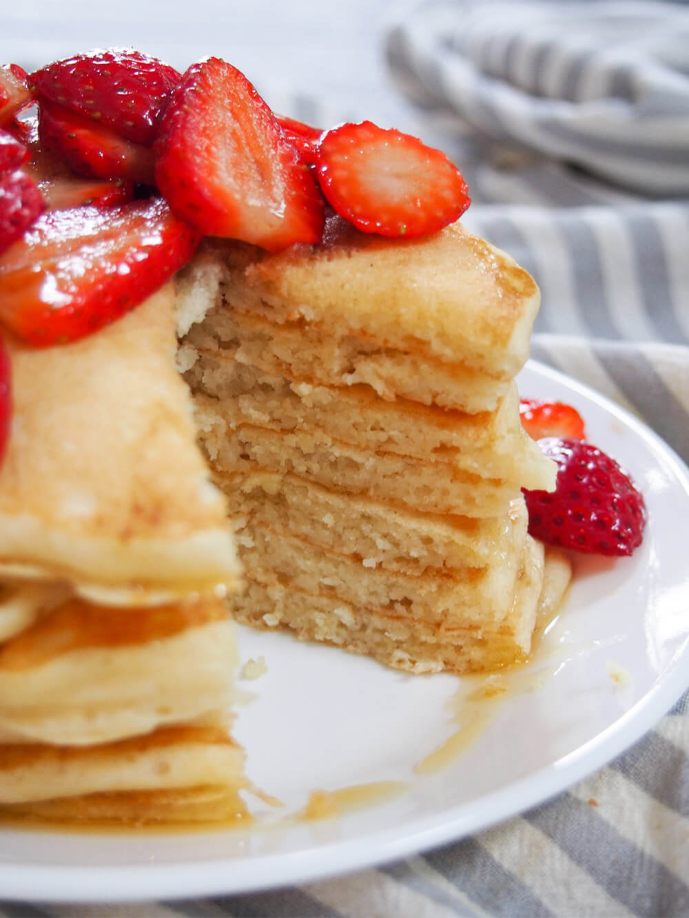 These sourdough pancakes are not only a great way to use sourdough discard, they taste amazing. Incredibly light and fluffy, they're also so easy to make. stack of pancakes with wedge cut through them