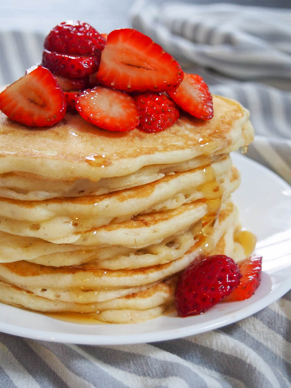 These sourdough pancakes are not only a great way to use sourdough discard, they taste amazing. Incredibly light and fluffy, they're also so easy to make. stack of sourdough pancakes with dripping syrup viewed from side