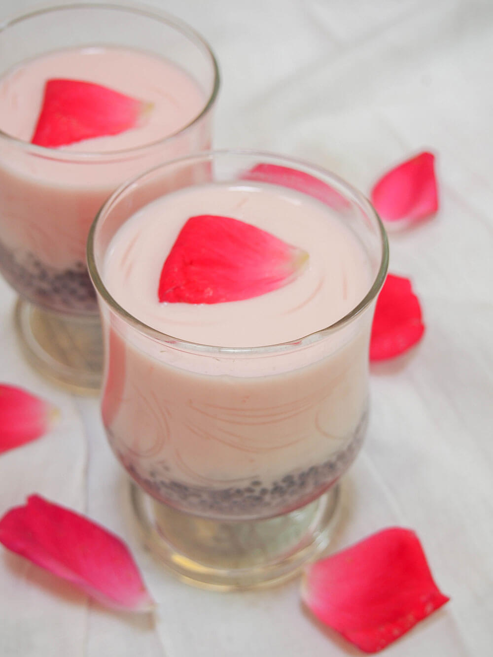 glass of falooda topped with a rose petal