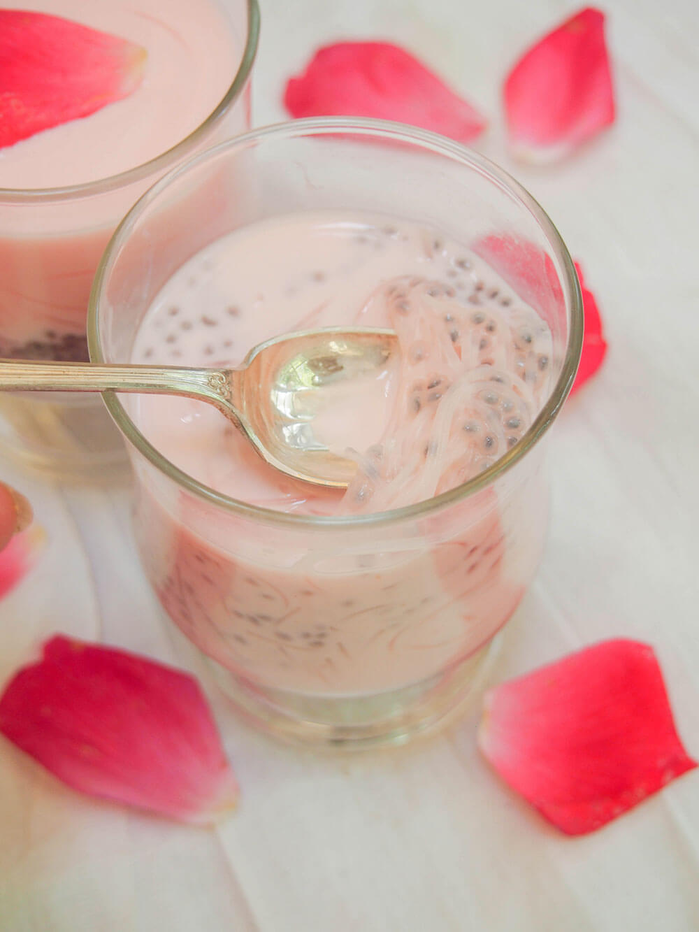 taking spoonful from glass of falooda