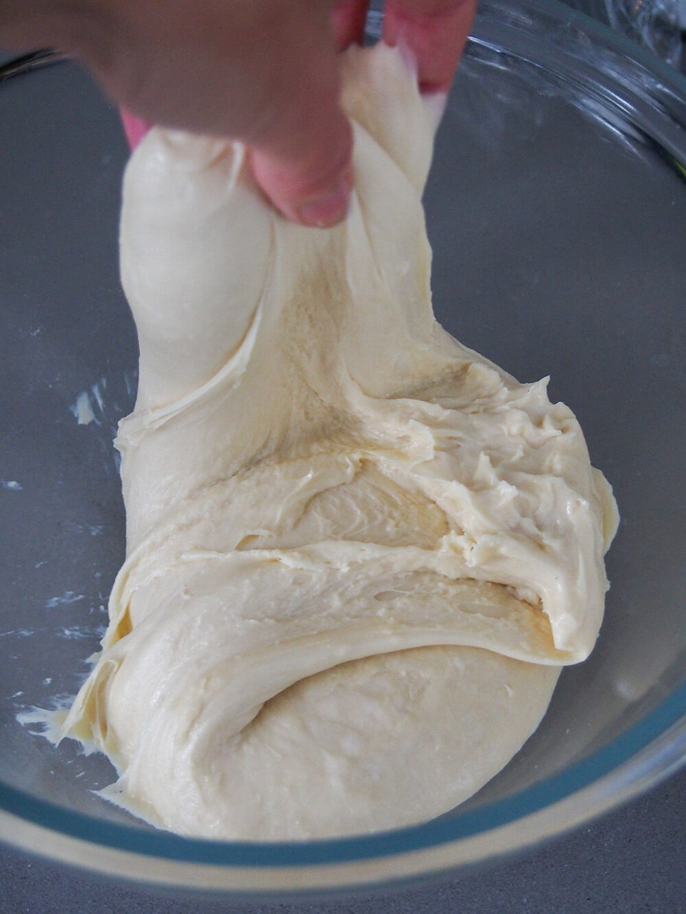 stretching and folding sourdough cinnamon rolls' dough during first rising process stretching and folding dough during first rising process