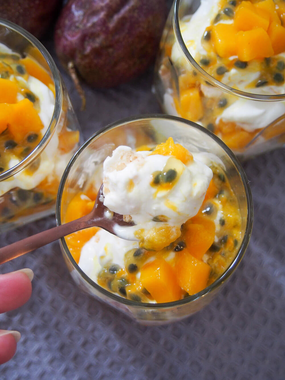 taking spoonful from a glass of mango passion fruit Eton mess