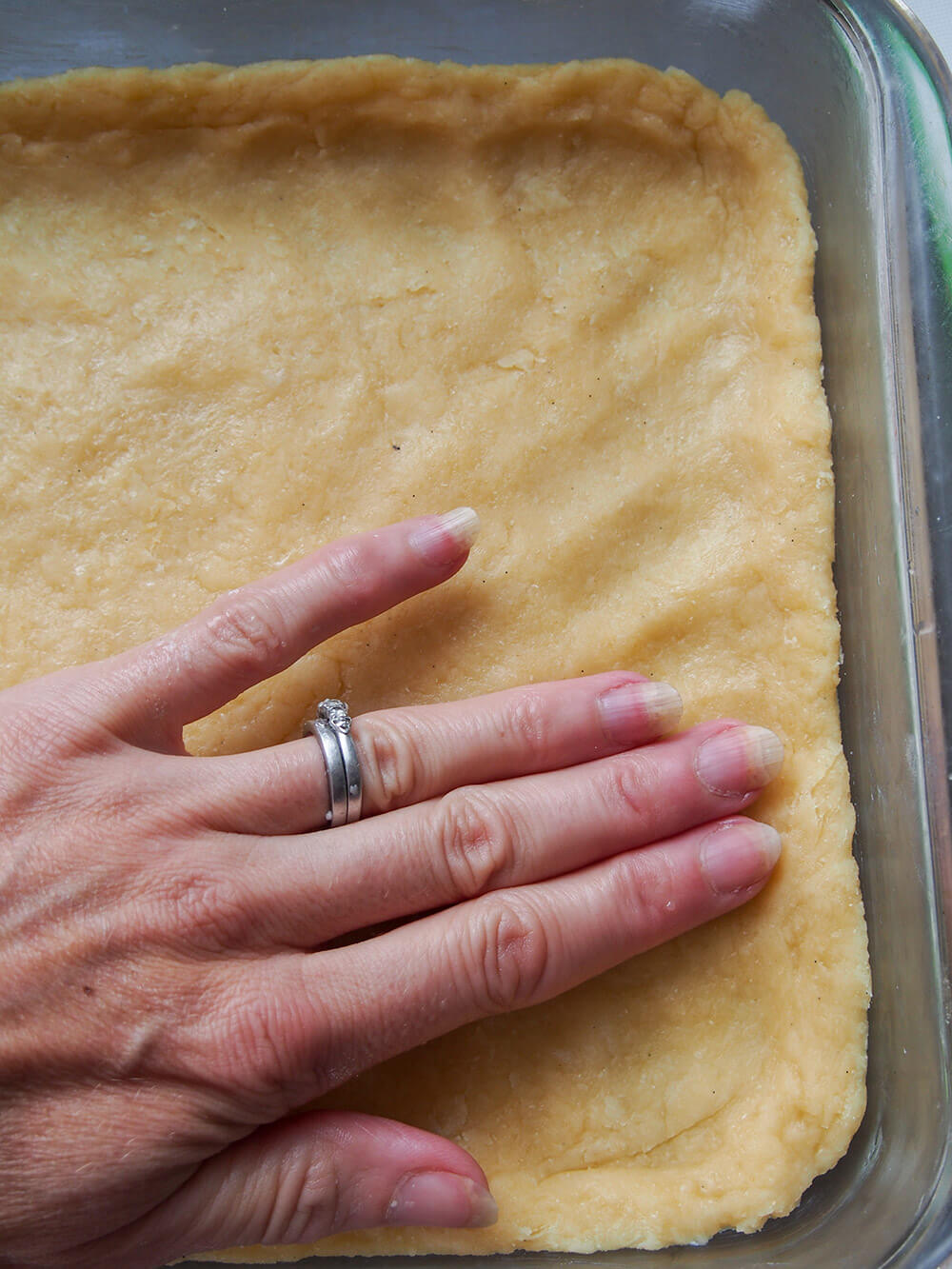 pressing cake base into dish 