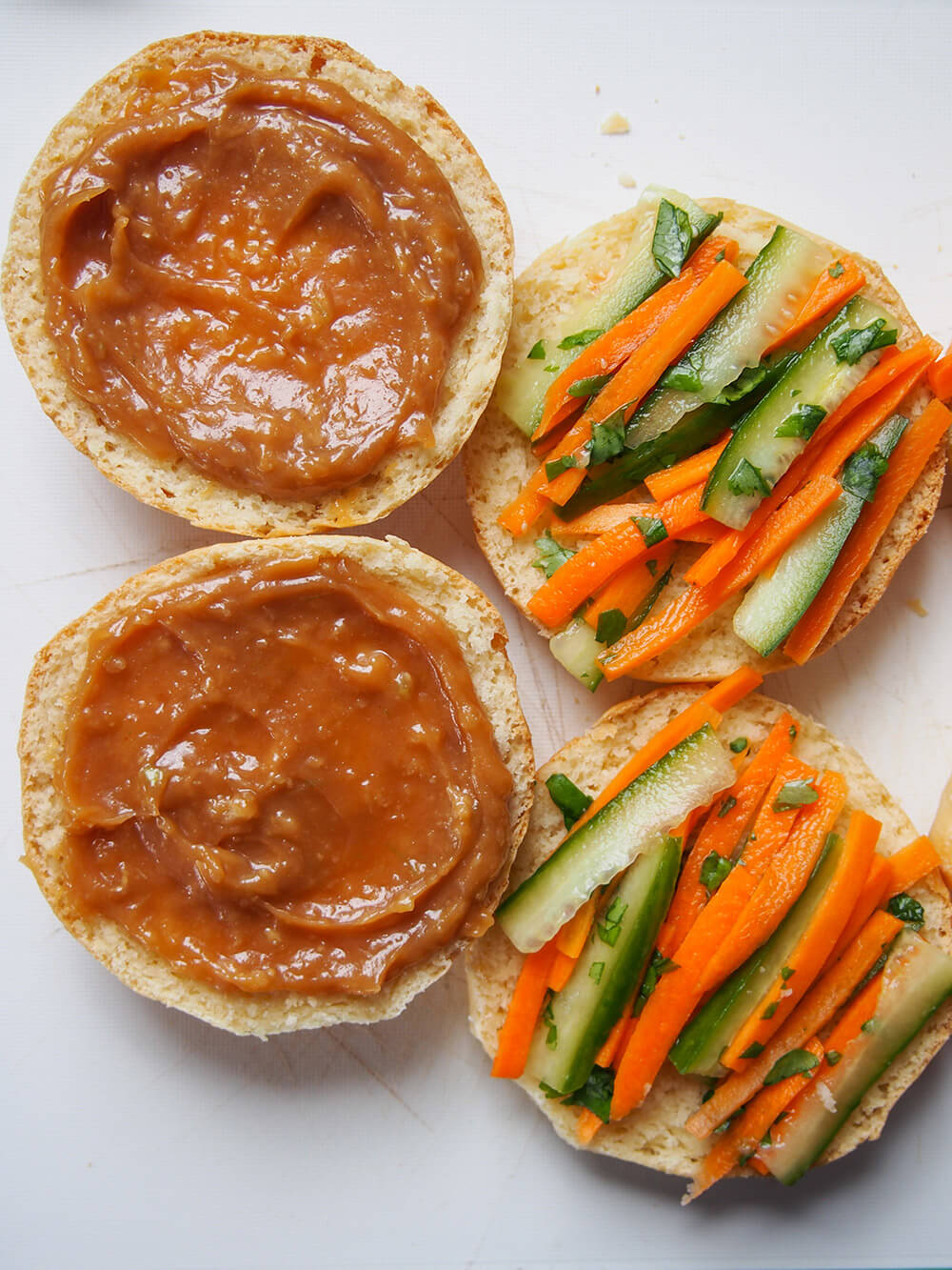 spreading sauce on top of bun and slaw to bottom 