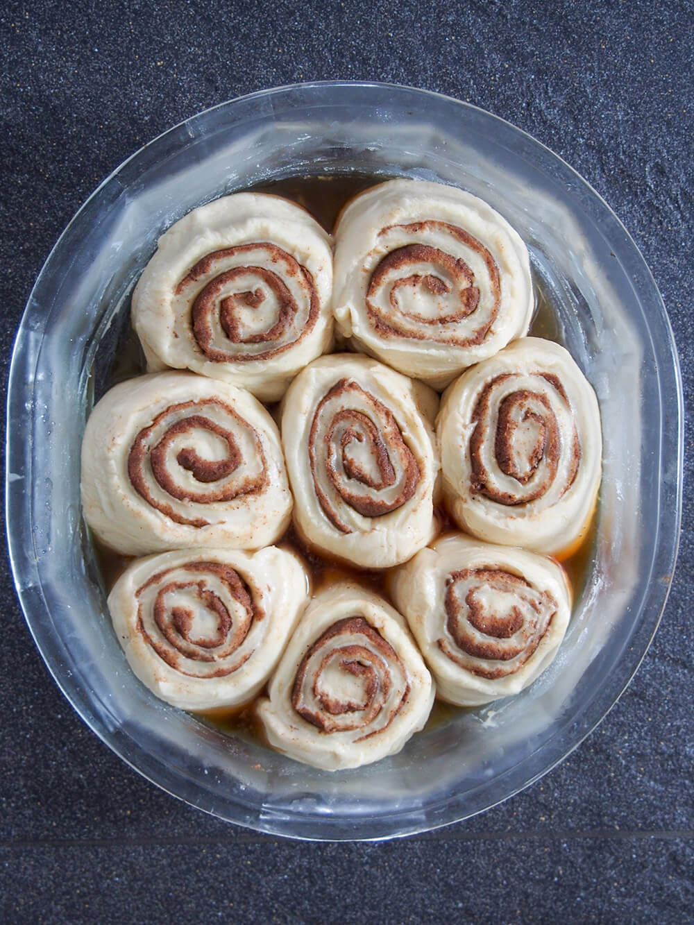 formed sourdough cinnamon rolls with some liquid formed below after being in fridge overnight formed sourdough cinnamon rolls with some liquid formed below after being in fridge overnight