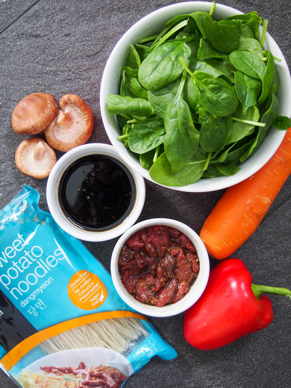 ingredients for japchae - noodles, vegetables, beef and sauce