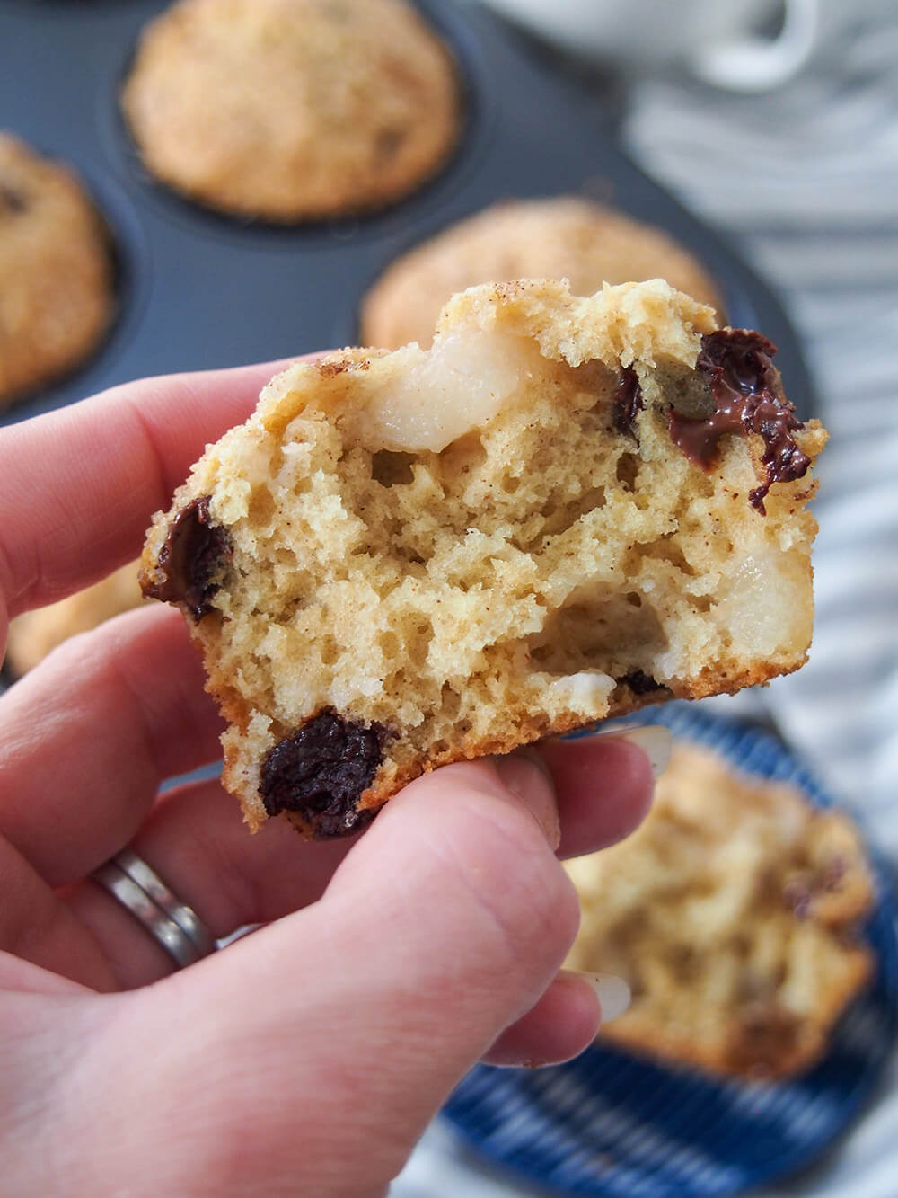 Half of a pear chocolate chip sourdough muffin held in hand