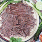 carne asada in slices on cutting board