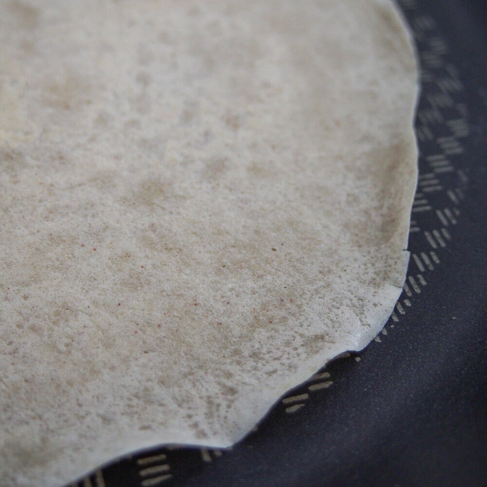 curled edge of cooking buckwheat crepe in skillet