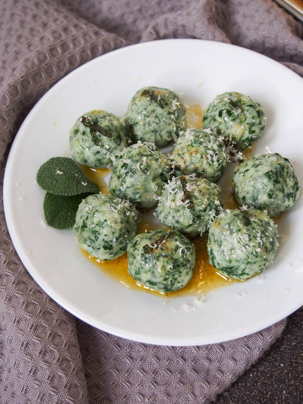 Ricotta and spinach gnudi are a little like gnocchi without the potato. They're light, cheesy and incredibly comforting and delicious! Ricotta and spinach gnudi topped with parmesan and with sage leaf garnish