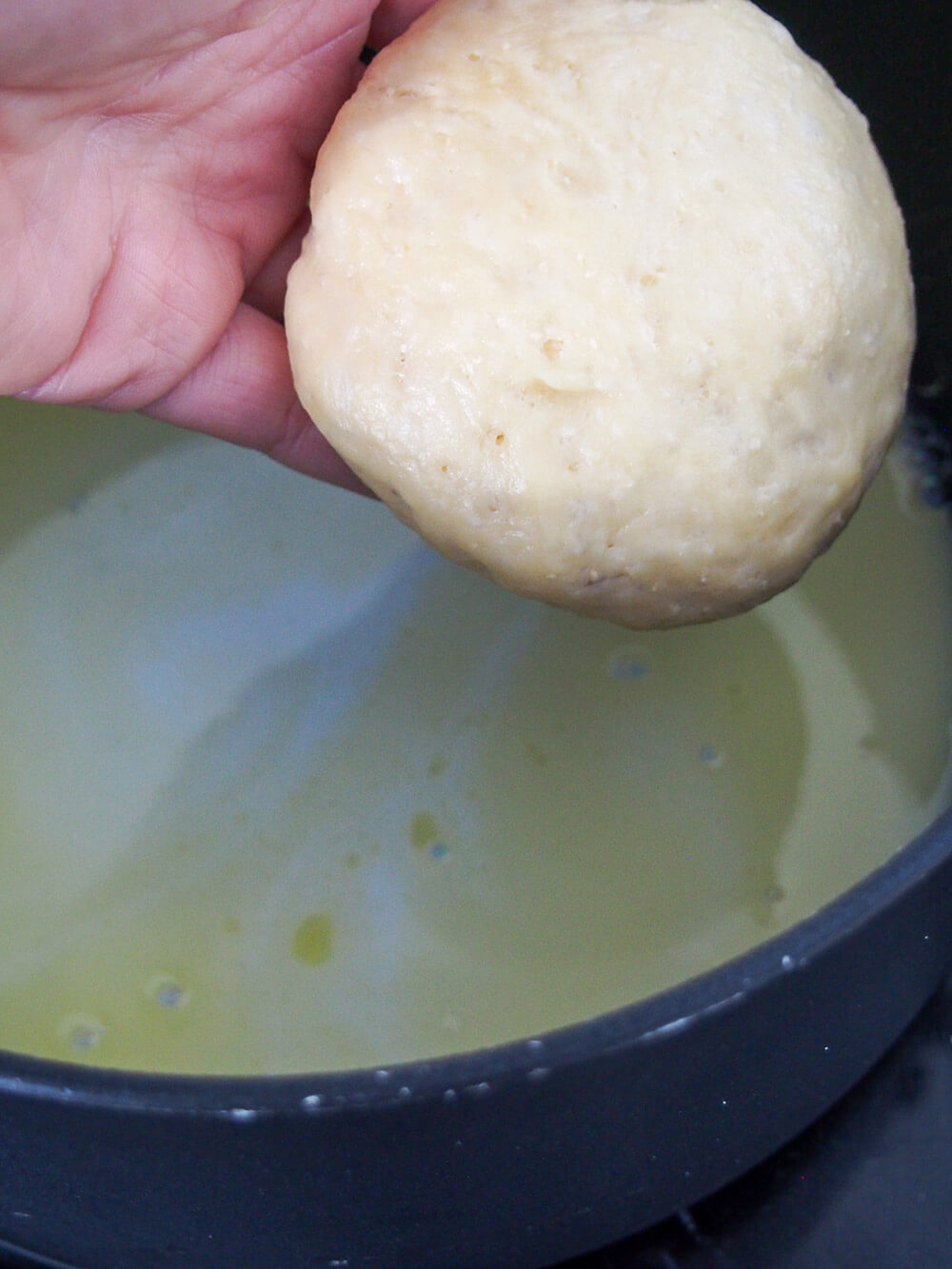 adding dampfnudel to pan to cook adding dampfnudel to pan to cook
