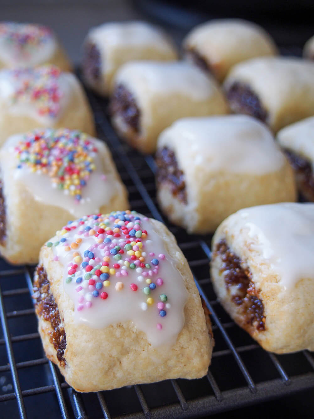 adding frosting and sprinkles to cucidati cookies