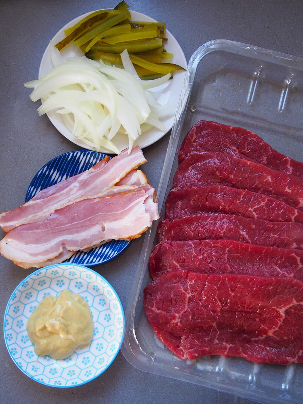 beef rouladen ingredients - slices of beef, mustard, bacon, onions and pickle slices