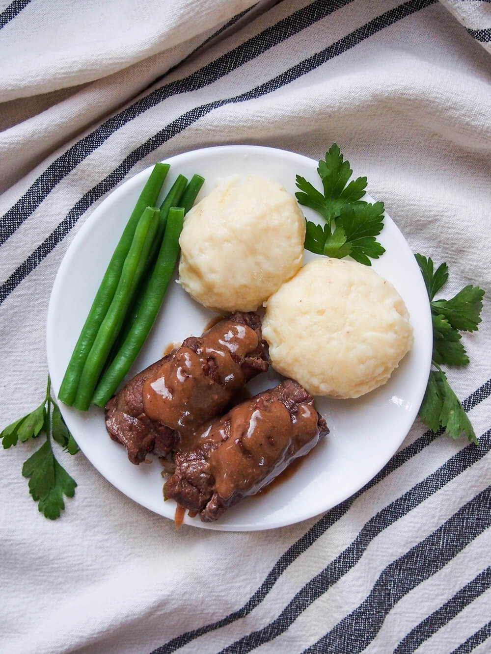 beef rouladen with sides on plate from overhead