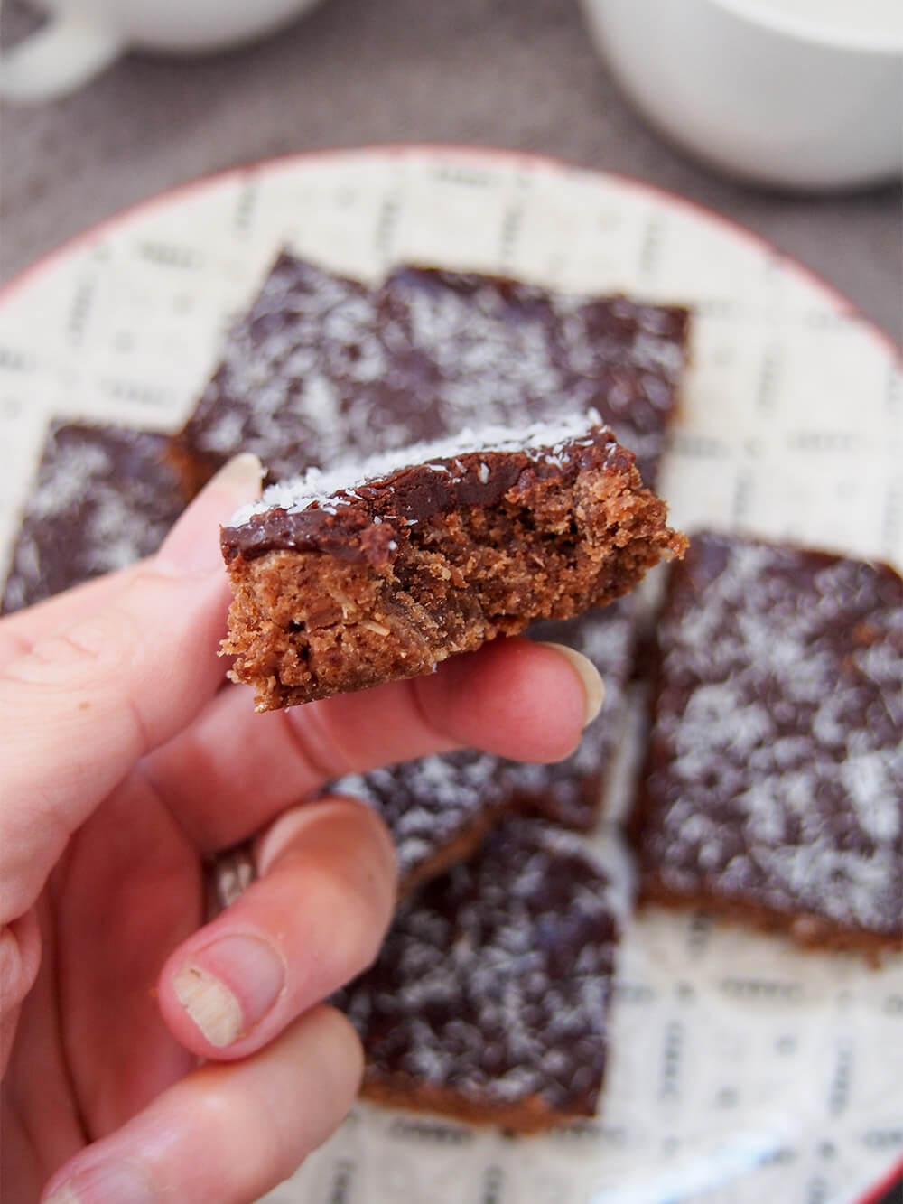 piece of chocolate slice in hand with bite taken from it