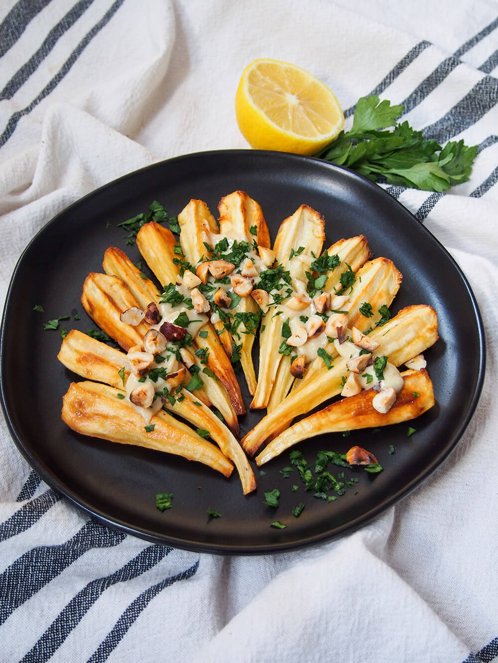 plate of finished dish with lemon and parsley behind