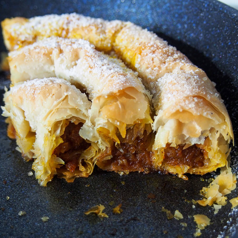 part of tikvenik in skillet showing filling in rolls