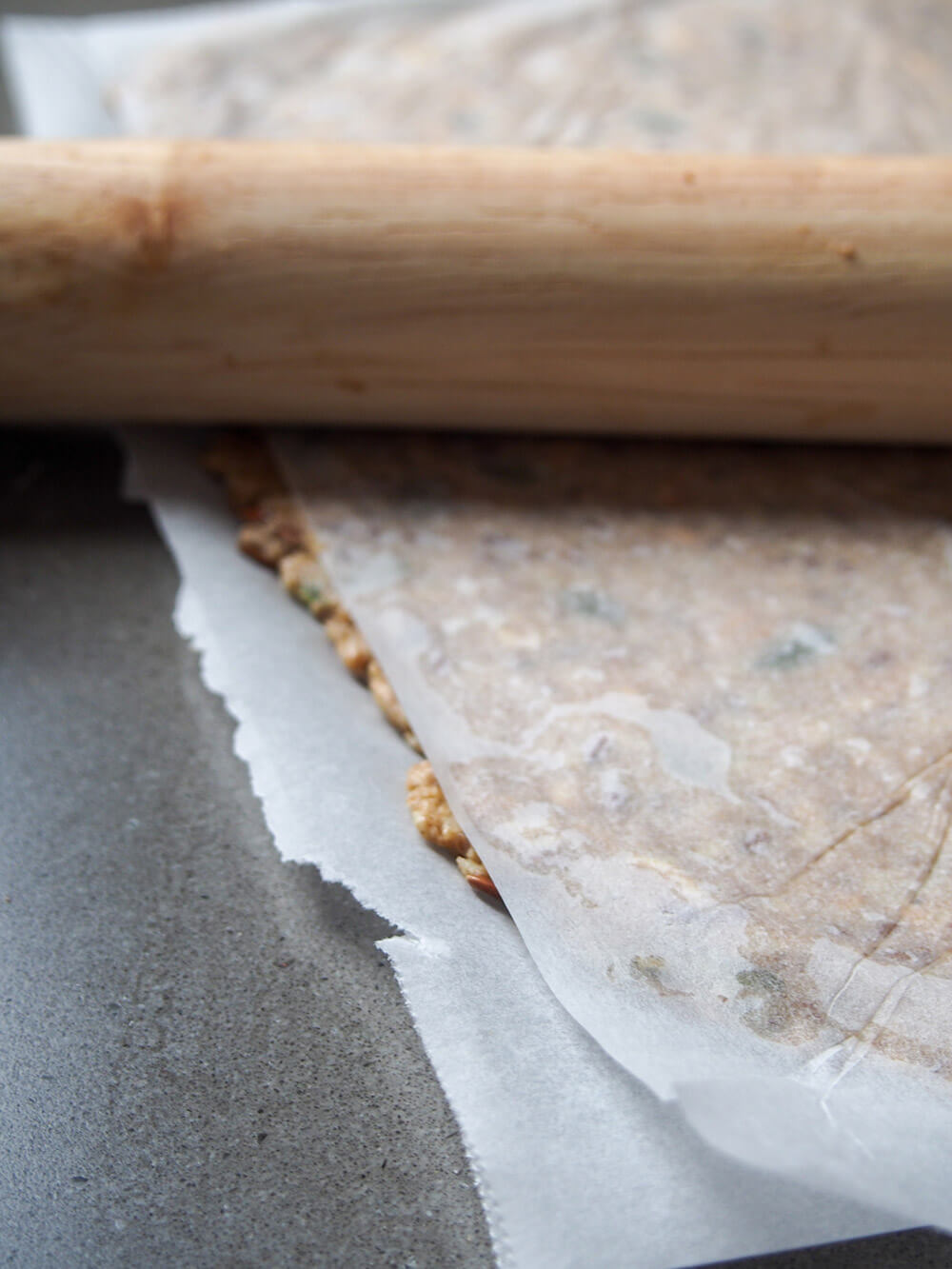 rolling out dough between sheets of parchment paper
