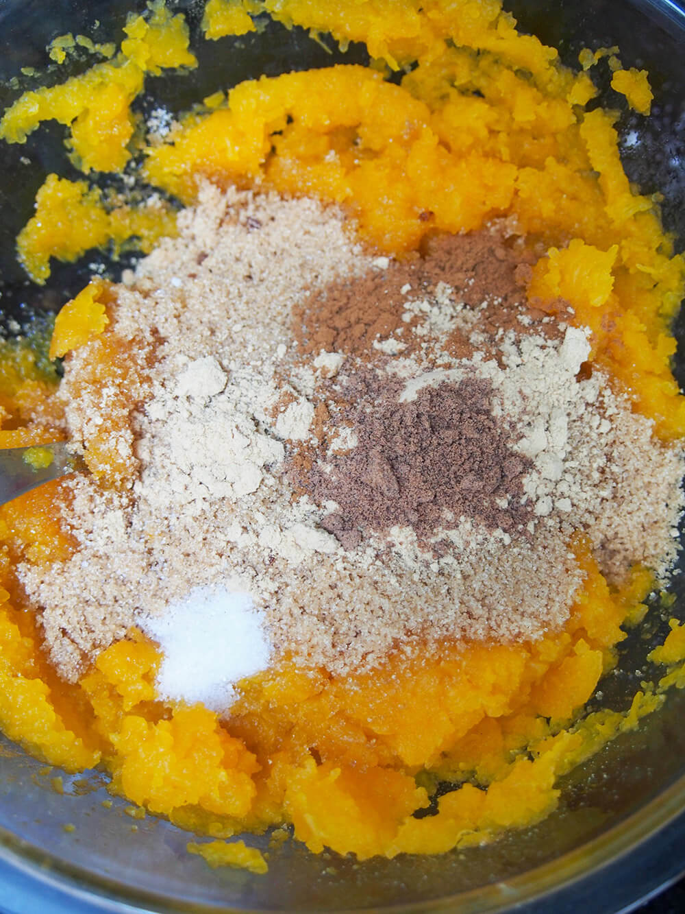 adding sugar and spices to pumpkin for filling