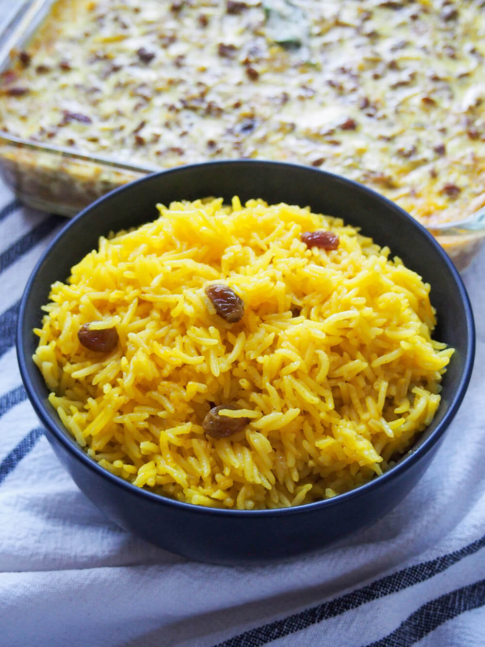 South African yellow rice served with bobotie behind