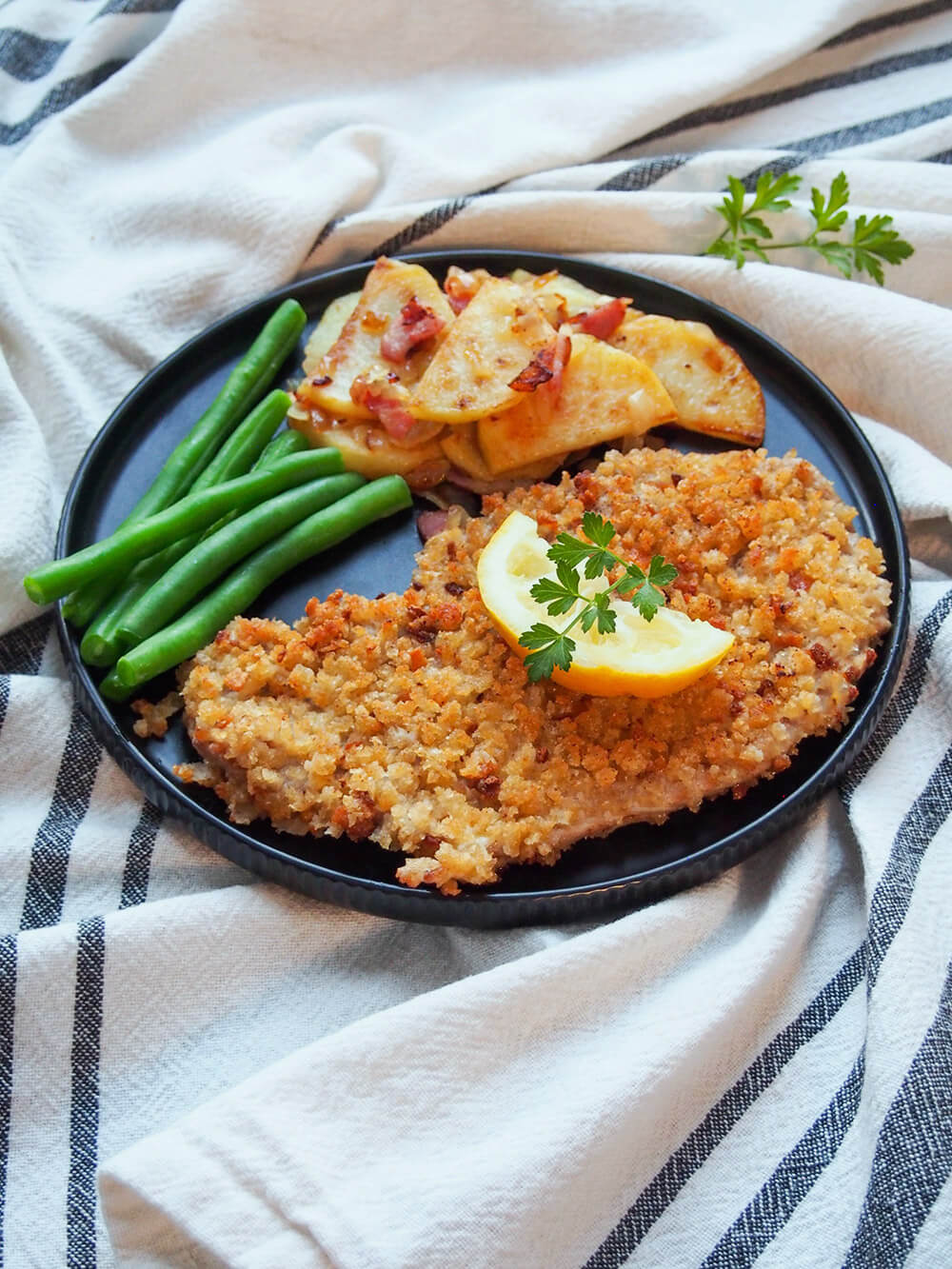 plate of Wiener schnitzel, beans and potatoes