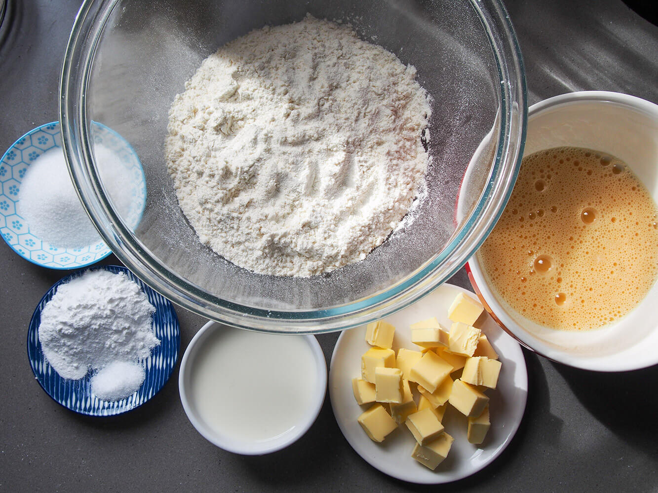 ingredients for British scones ingredients on separate small dishes (flour, butter etc)