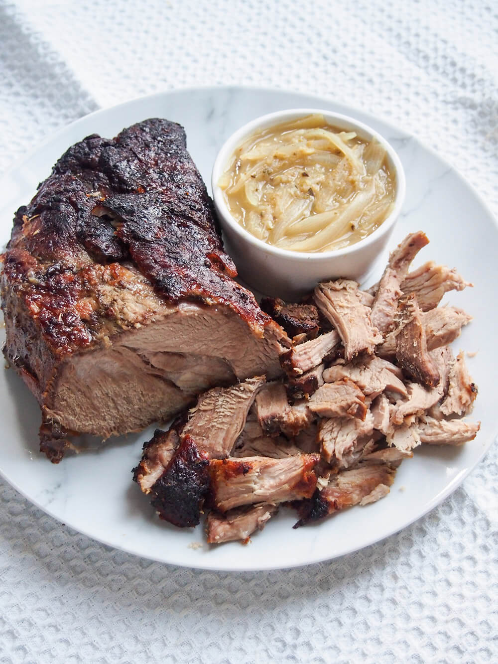 plate of lechon asado Cuban roast pork with some cut and mojo sauce to side