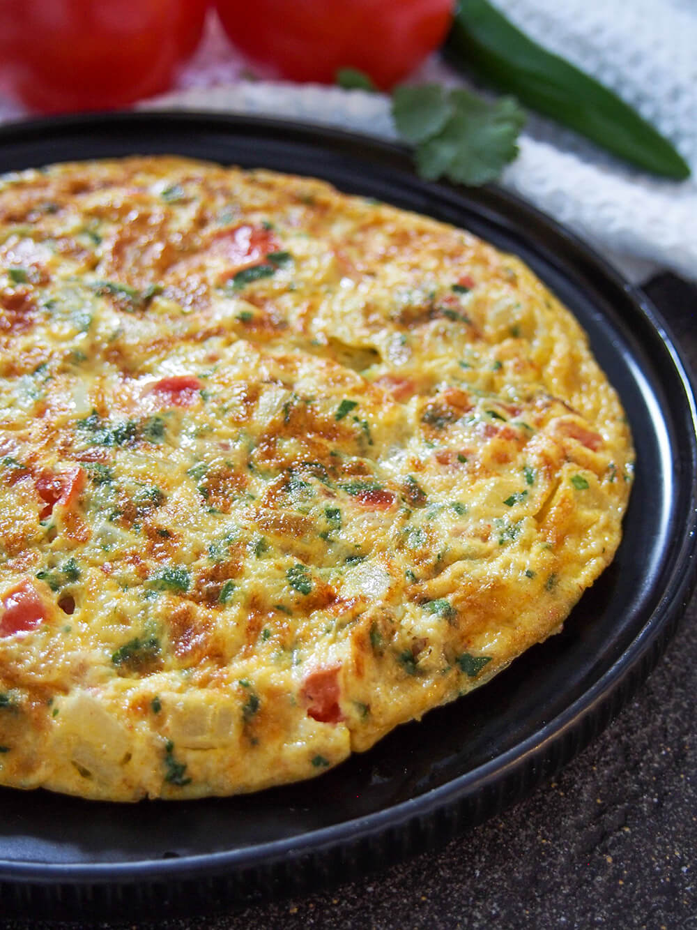 Masala omelette is a popular Indian breakfast and a great way to change up your usual omelette. It's quick to make, with a simple combination of vegetables and a bit of spice. side view of masala omelette