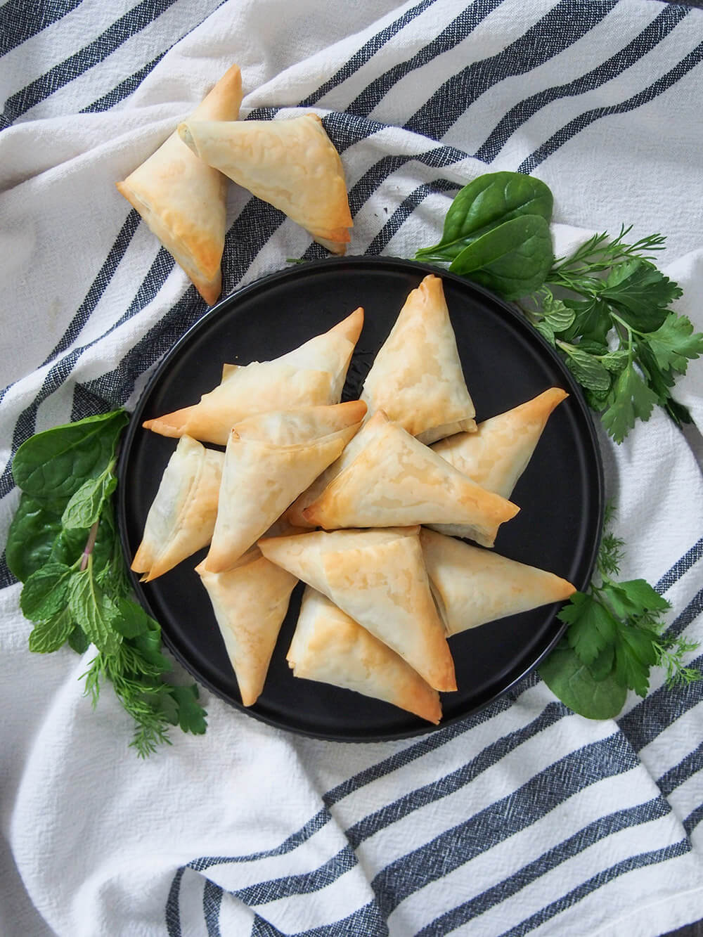 plate of spanakopita triangles from overhead