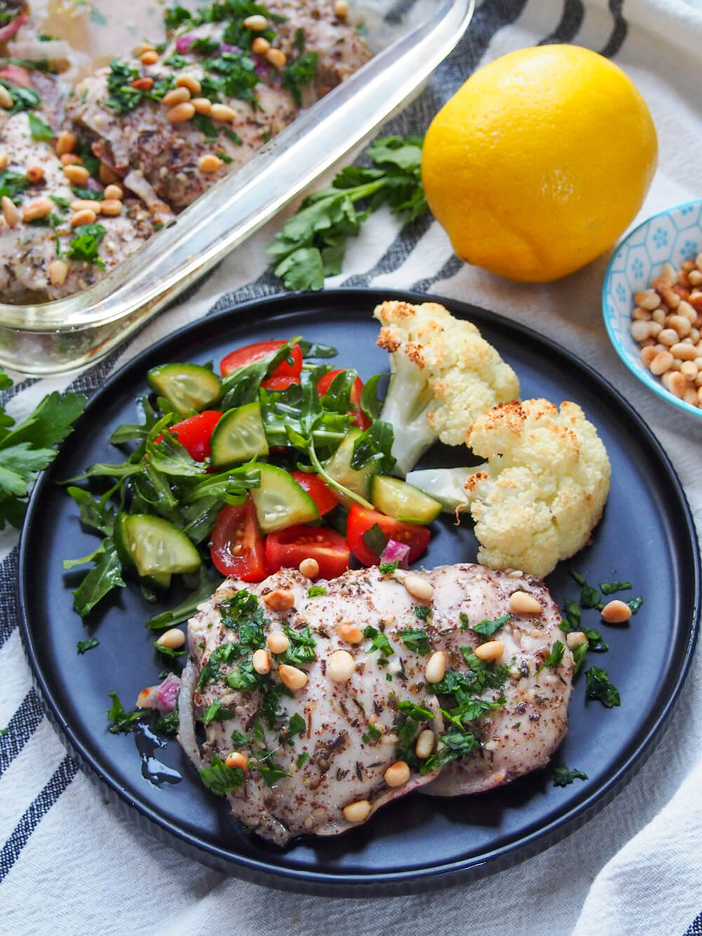 piece of chickrn served on plate with salad and roasted cauliflower