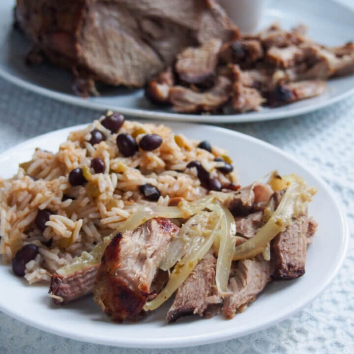 plate of lechon asado Cuban roast pork with rice and beans side