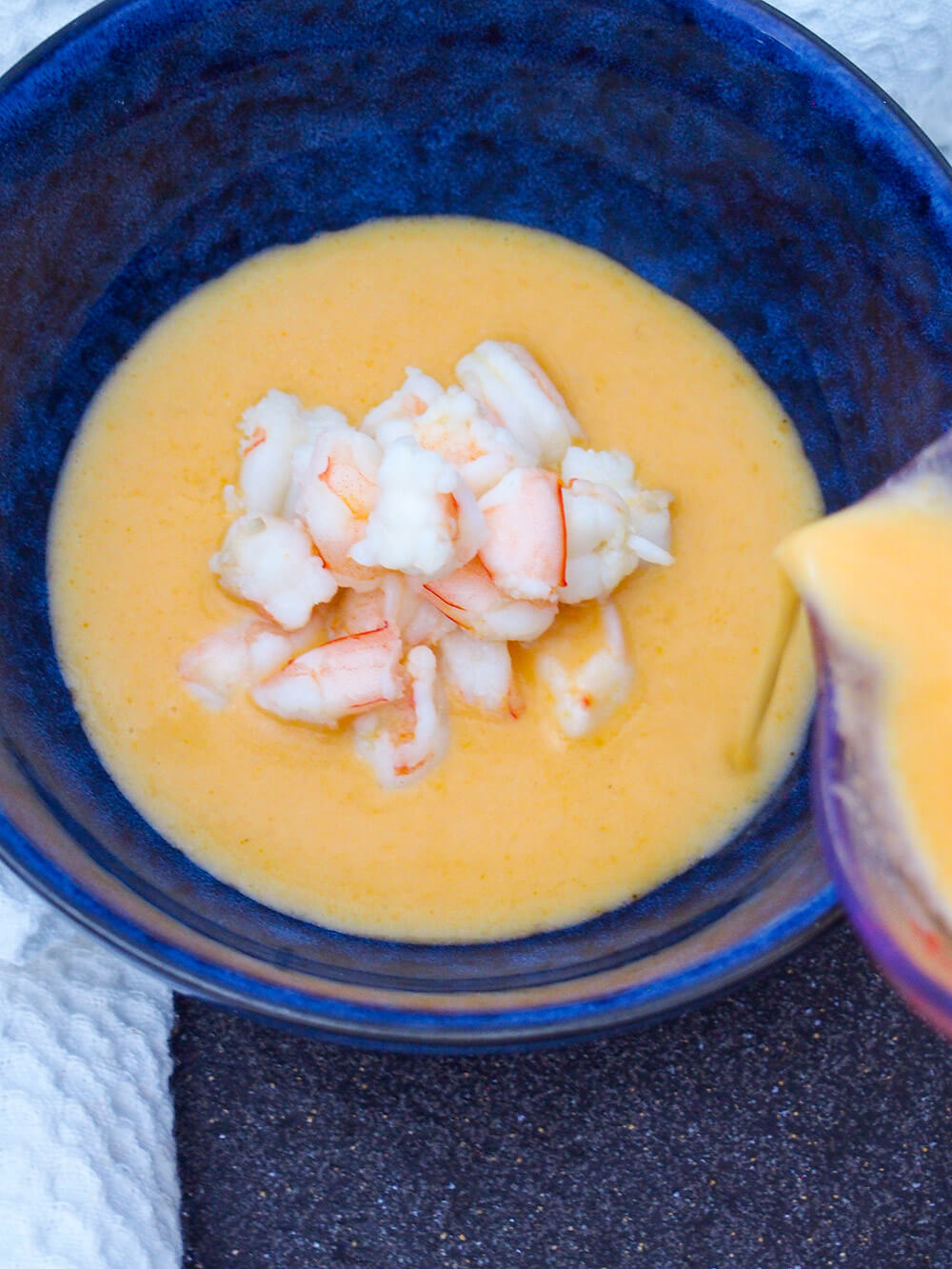 pouring bisque into bowl around shrimp pouring bisque into bowl around shrimp