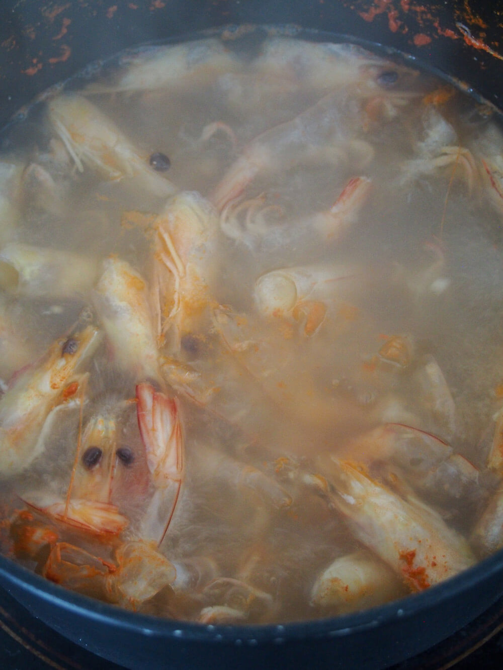 simmering shrimp heads and skins to make shrimp stock for shrimp bisque simmering shrimp heads and skins to make shrimp stock