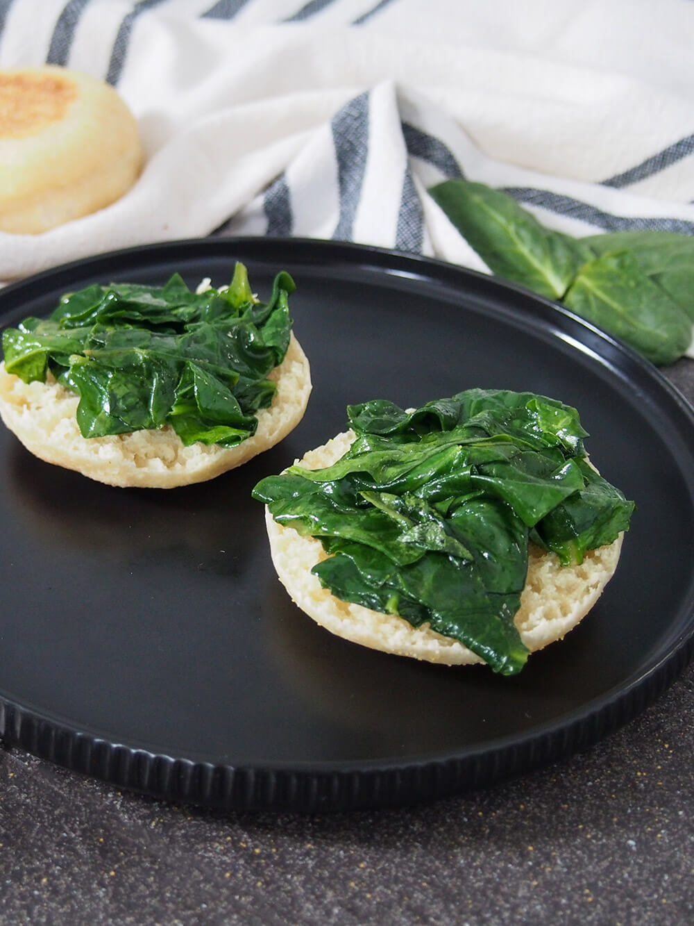 sauteed spinach on top of halves of English muffin