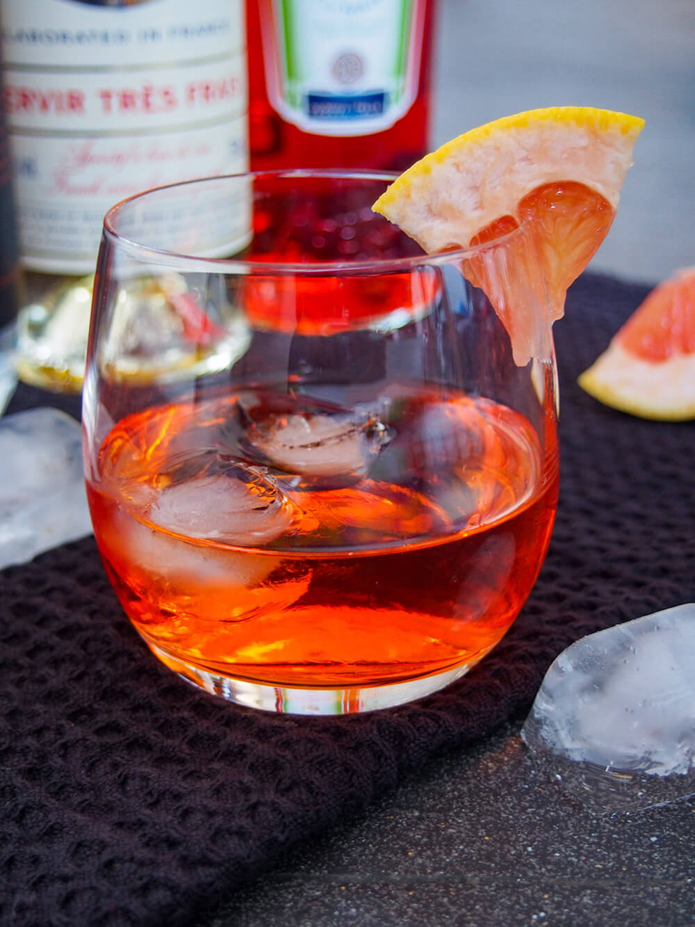 This unusual negroni has the same style of flavors as the classic, but is that bit more mellow and aromatic. Easy and wonderfully sippable. unusual negroni with bottles behind glass
