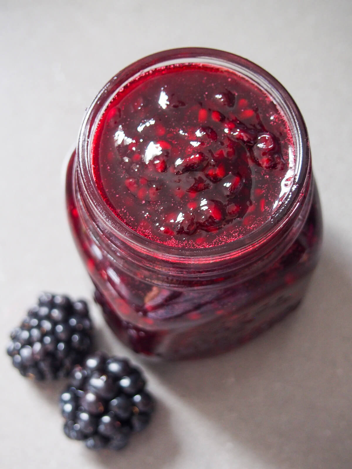 jar of blackberry jam with blackberries to side